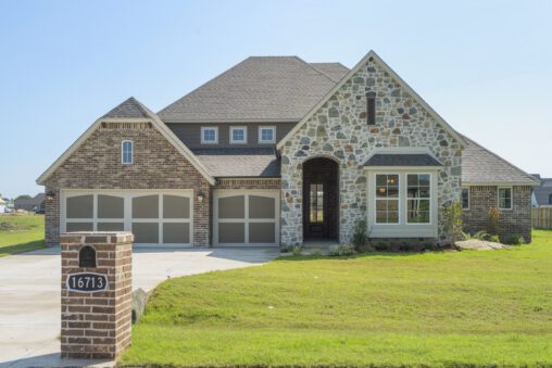 New suburban house with a brick and stone facade, double garage, and a lawn, located at address 16713.