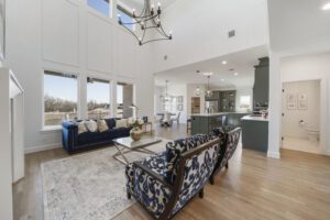 Spacious living room with high ceilings, contemporary furnishings, and an open floor plan integrating the kitchen area.