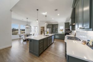 Modern kitchen with a central island, pendant lighting, and stainless steel appliances.