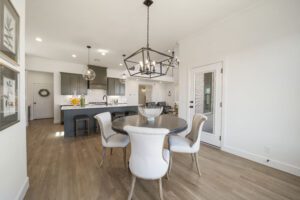 Modern open-plan kitchen and dining area with a neutral color palette and hardwood floors.